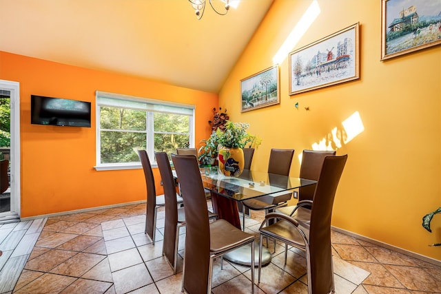 tiled dining area featuring baseboards and vaulted ceiling