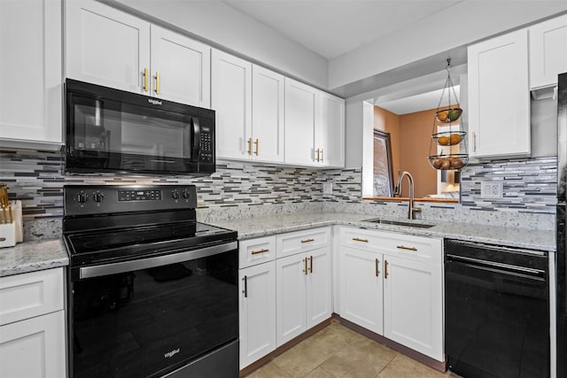 kitchen featuring a sink, black appliances, and white cabinetry