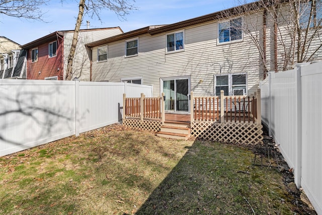 back of house with a wooden deck, a yard, and a fenced backyard