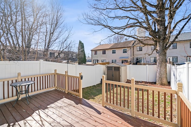 wooden terrace with an outbuilding, a shed, a fenced backyard, and a residential view