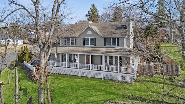 farmhouse with a front lawn, covered porch, and a shingled roof