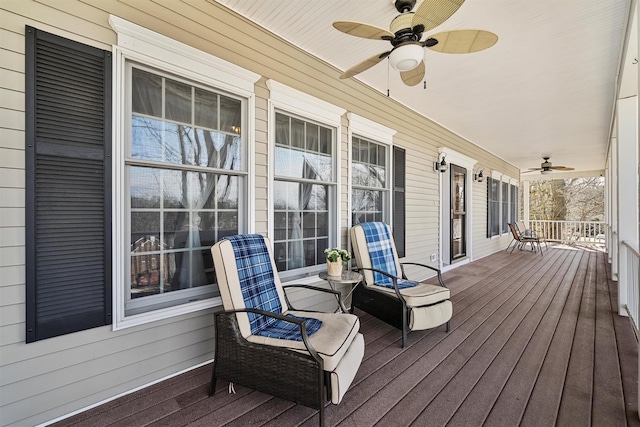 wooden deck featuring a porch and a ceiling fan