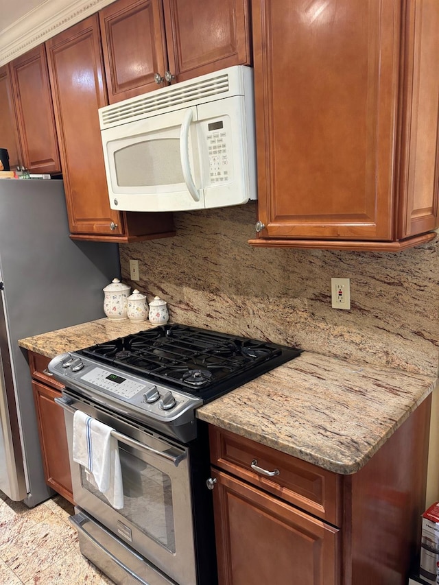 42-30 196th St, Flushing, NY 11358 - kitchen with light stone countertops, brown cabinets, decorative backsplash, white microwave, and stainless steel gas range oven