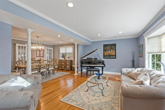 living room featuring baseboards, light wood-style flooring, ornamental molding, and ornate columns