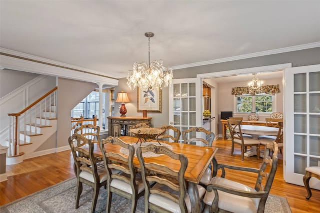 dining room with stairs, ornamental molding, wood finished floors, and a chandelier