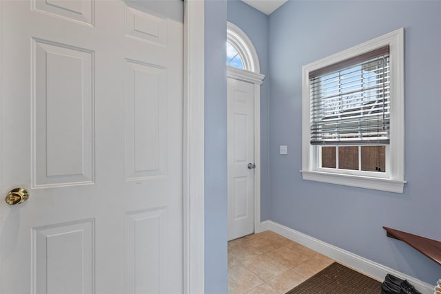 foyer entrance with light tile patterned flooring and baseboards