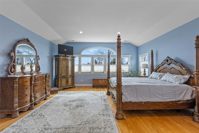 bedroom featuring wood finished floors and vaulted ceiling