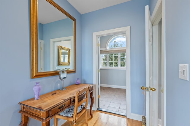 doorway with light wood-type flooring and baseboards