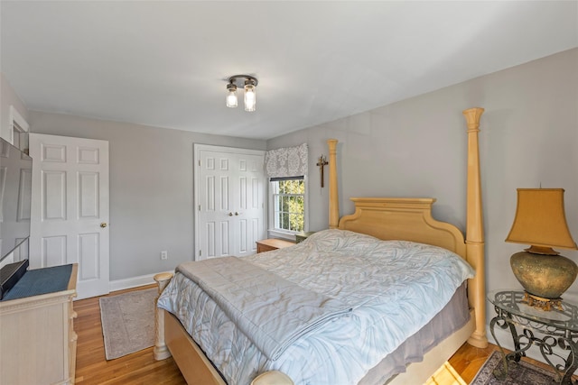 bedroom featuring a closet, baseboards, and wood finished floors