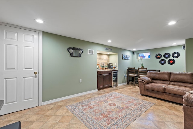 living room featuring a bar, wine cooler, recessed lighting, and visible vents