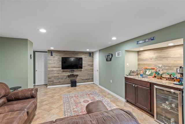 living area with beverage cooler, visible vents, recessed lighting, a bar, and an accent wall