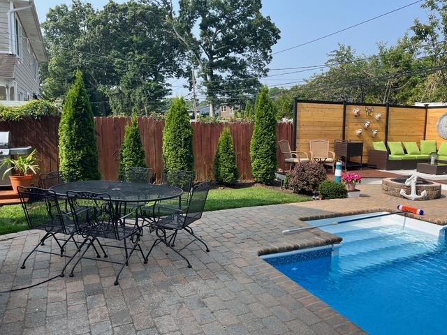 view of pool featuring outdoor dining space, a patio, fence, an outdoor fire pit, and a fenced in pool