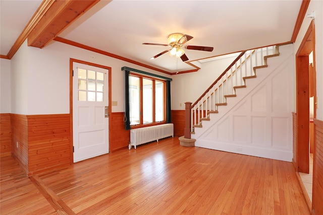 entryway with stairs, light wood-style floors, wainscoting, and radiator