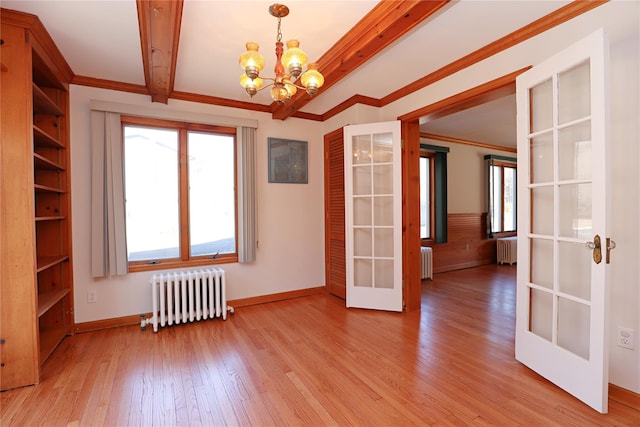 spare room with radiator, beam ceiling, and french doors