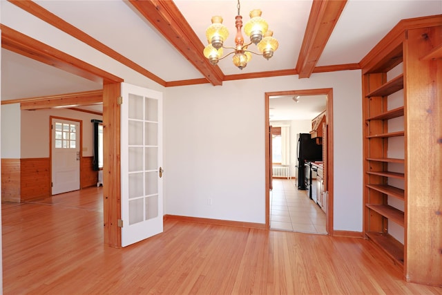 unfurnished room with a notable chandelier, built in features, light wood-style floors, radiator, and beamed ceiling