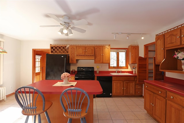 kitchen with light tile patterned floors, custom range hood, a kitchen island, a sink, and black appliances