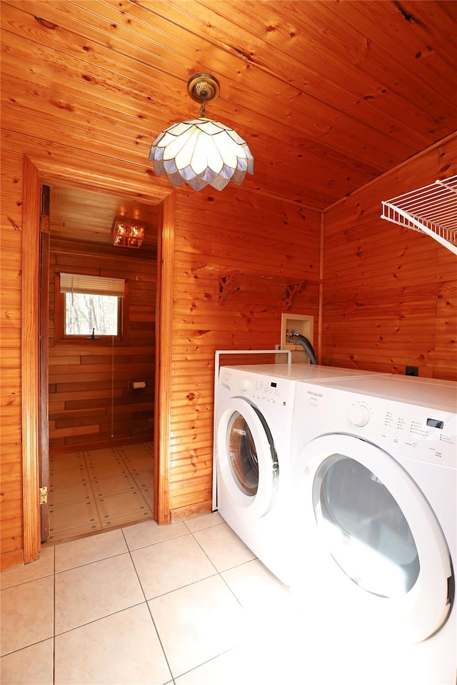 washroom with washing machine and dryer, wood ceiling, wooden walls, and light tile patterned floors