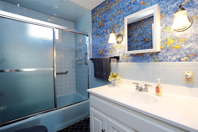 bathroom featuring wainscoting, enclosed tub / shower combo, vanity, and wallpapered walls