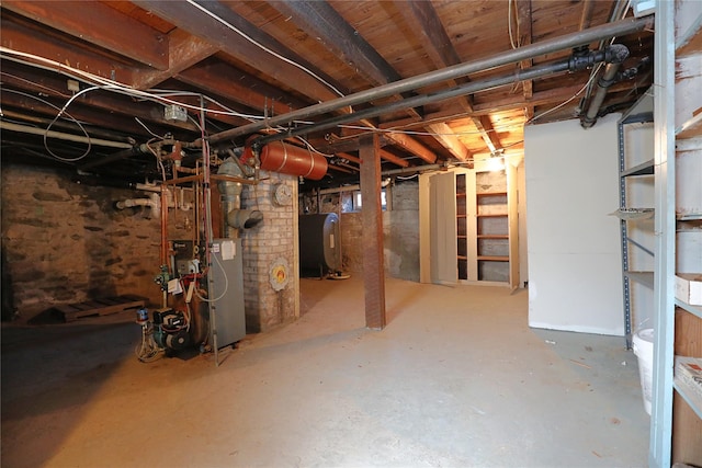 unfinished basement with a heating unit and heating fuel