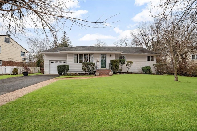 ranch-style home featuring aphalt driveway, a garage, fence, and a front yard