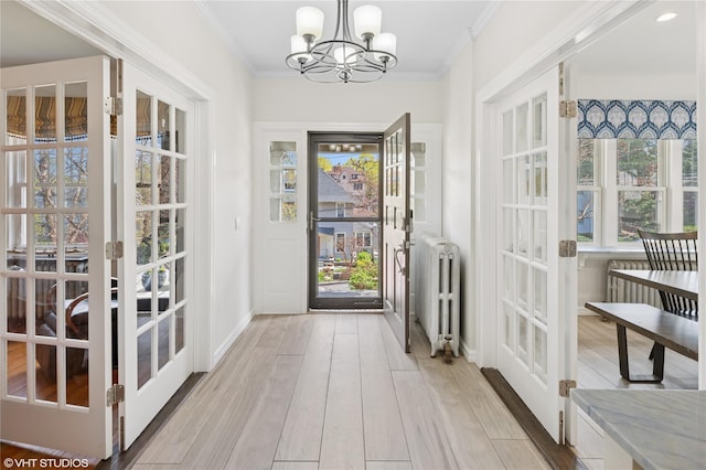 119 Cassilis Ave, Bronxville, NY 10708 - entrance foyer with radiator heating unit, french doors, a chandelier, light wood-style floors, and ornamental molding