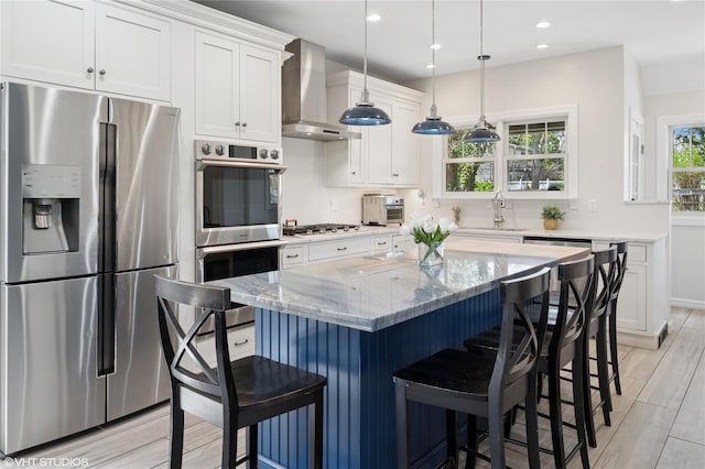 119 Cassilis Ave, Bronxville, NY 10708 - kitchen featuring stainless steel appliances, wall chimney exhaust hood, a sink, white cabinetry, and light stone countertops
