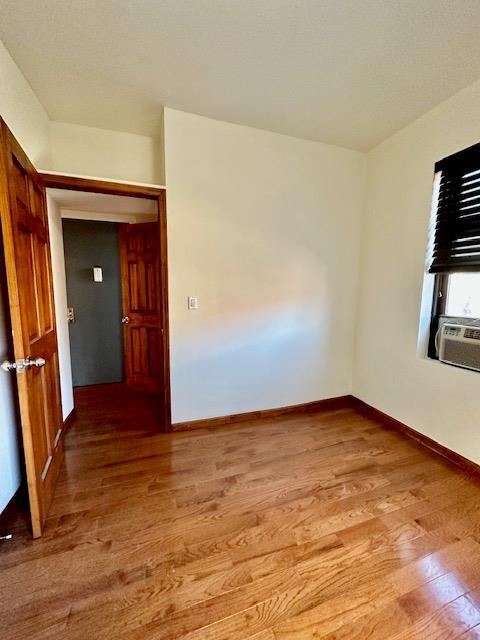 unfurnished room with light wood-style flooring and baseboards