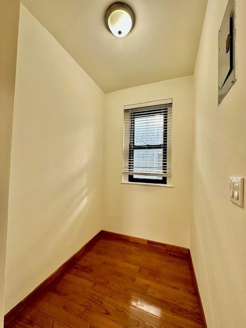 spare room featuring baseboards, vaulted ceiling, and hardwood / wood-style floors