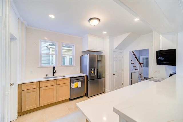 kitchen with dishwashing machine, ornamental molding, a sink, light countertops, and stainless steel fridge