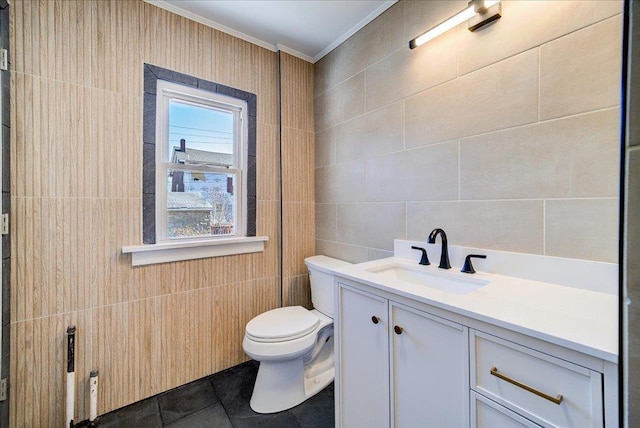 bathroom with toilet, tile walls, crown molding, tile patterned flooring, and vanity