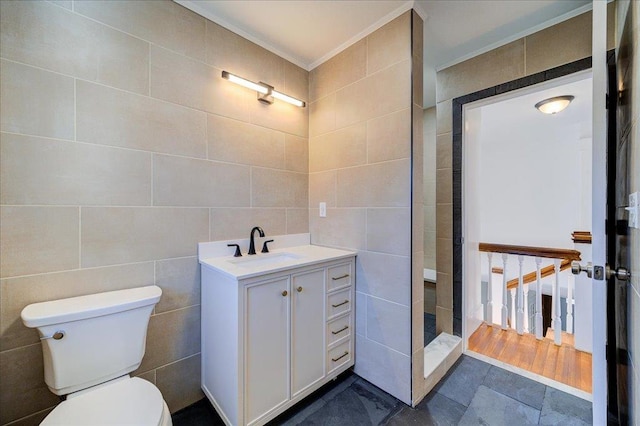 full bath with walk in shower, toilet, vanity, ornamental molding, and tile walls