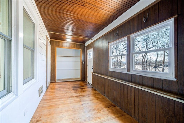 interior space with visible vents, wooden walls, wood ceiling, and light wood-style floors