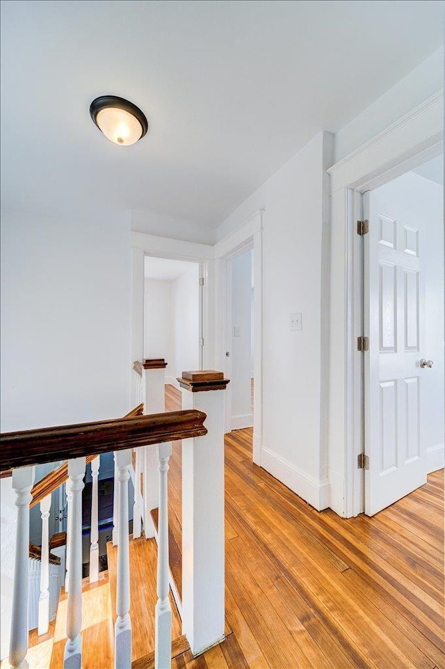 hallway featuring light wood-style floors and baseboards