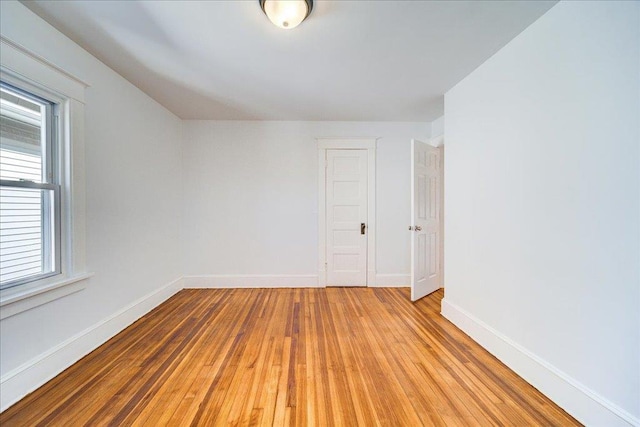 unfurnished room featuring baseboards and light wood-type flooring