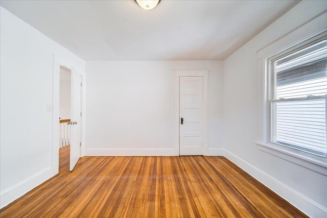 empty room with baseboards and wood finished floors