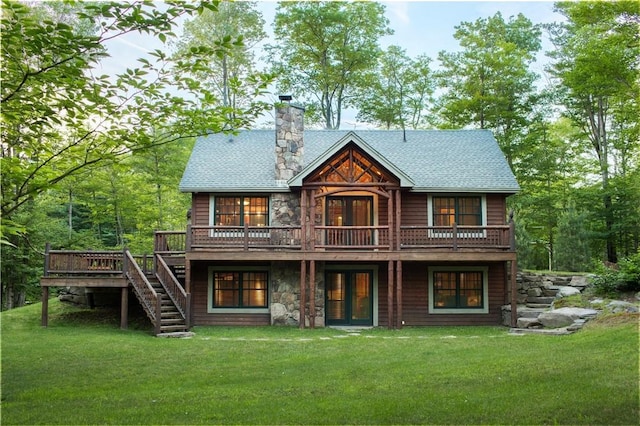 rear view of house with french doors, a shingled roof, a lawn, a wooden deck, and stairs