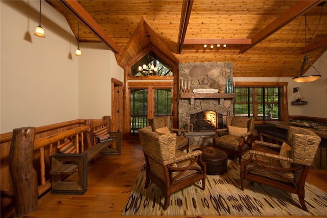 sitting room featuring wood ceiling, wood-type flooring, beamed ceiling, a stone fireplace, and high vaulted ceiling