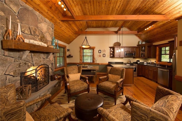 interior space with vaulted ceiling with beams, light wood-type flooring, wooden ceiling, and a fireplace