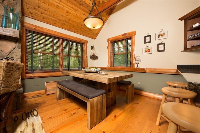 dining room with light wood-style floors, wood ceiling, baseboards, and vaulted ceiling