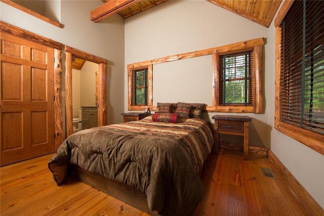 bedroom with high vaulted ceiling, connected bathroom, visible vents, beam ceiling, and wood-type flooring