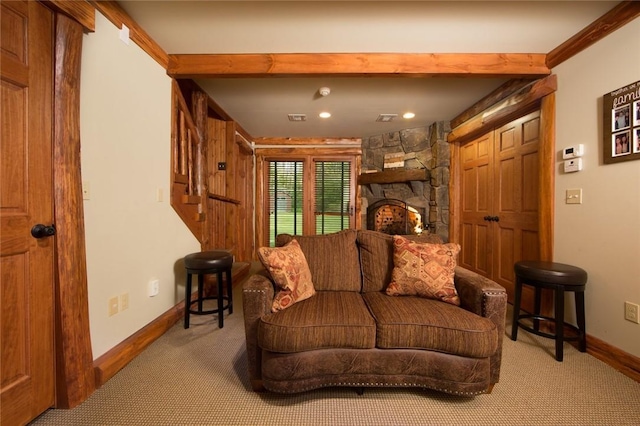 carpeted living area featuring a fireplace, beam ceiling, and baseboards