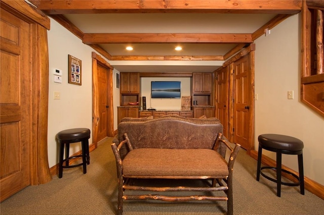 living area featuring carpet floors, beam ceiling, and baseboards