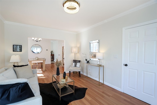 living room featuring an inviting chandelier, baseboards, ornamental molding, and light wood finished floors