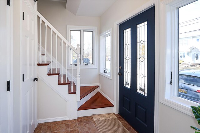 foyer entrance featuring baseboards and stairway