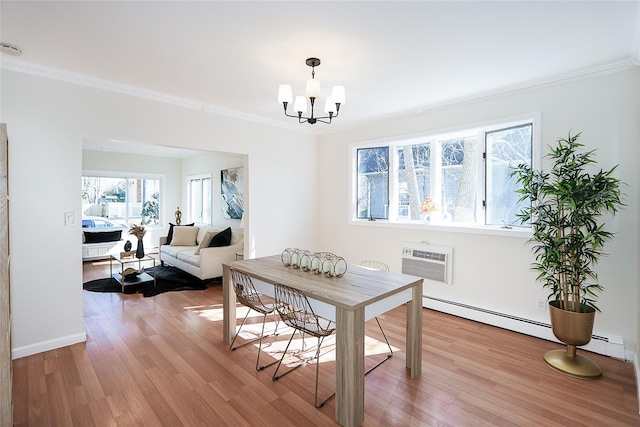 dining area featuring light wood-style floors, a notable chandelier, ornamental molding, and an AC wall unit