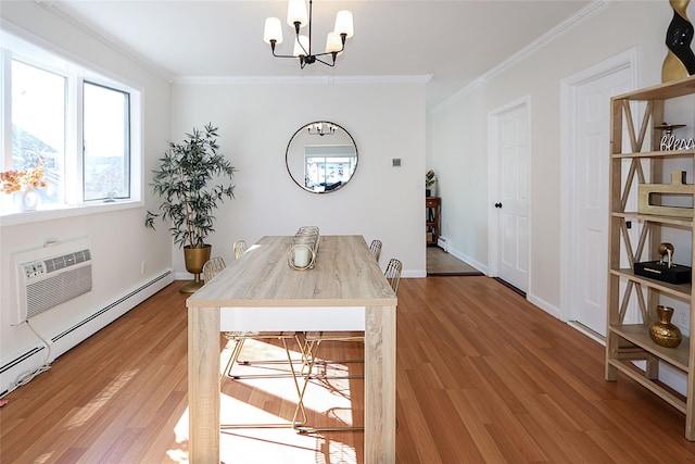 dining space featuring ornamental molding, an AC wall unit, a notable chandelier, and light wood-style flooring