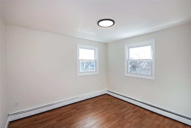 spare room with a baseboard radiator and wood finished floors