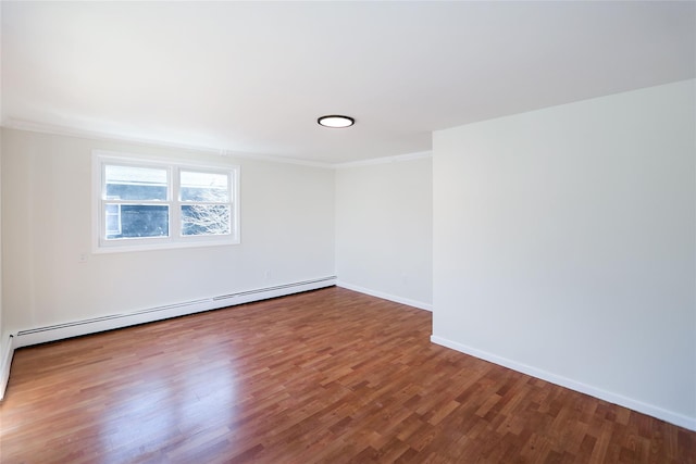 empty room with a baseboard heating unit, crown molding, wood finished floors, and baseboards