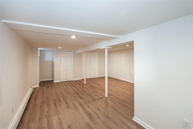 finished basement with light wood-type flooring, baseboard heating, baseboards, and recessed lighting