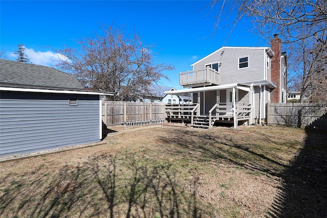 view of yard featuring a balcony and a fenced backyard